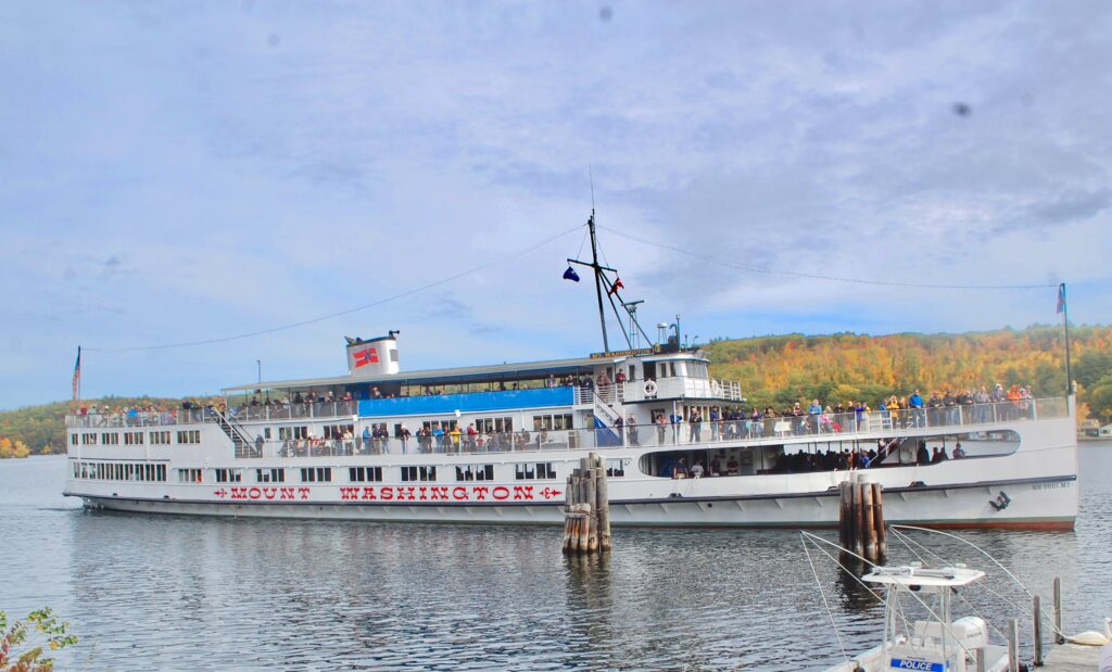 Mount Washington cruise ship with people on board and beautiful foliage in the background