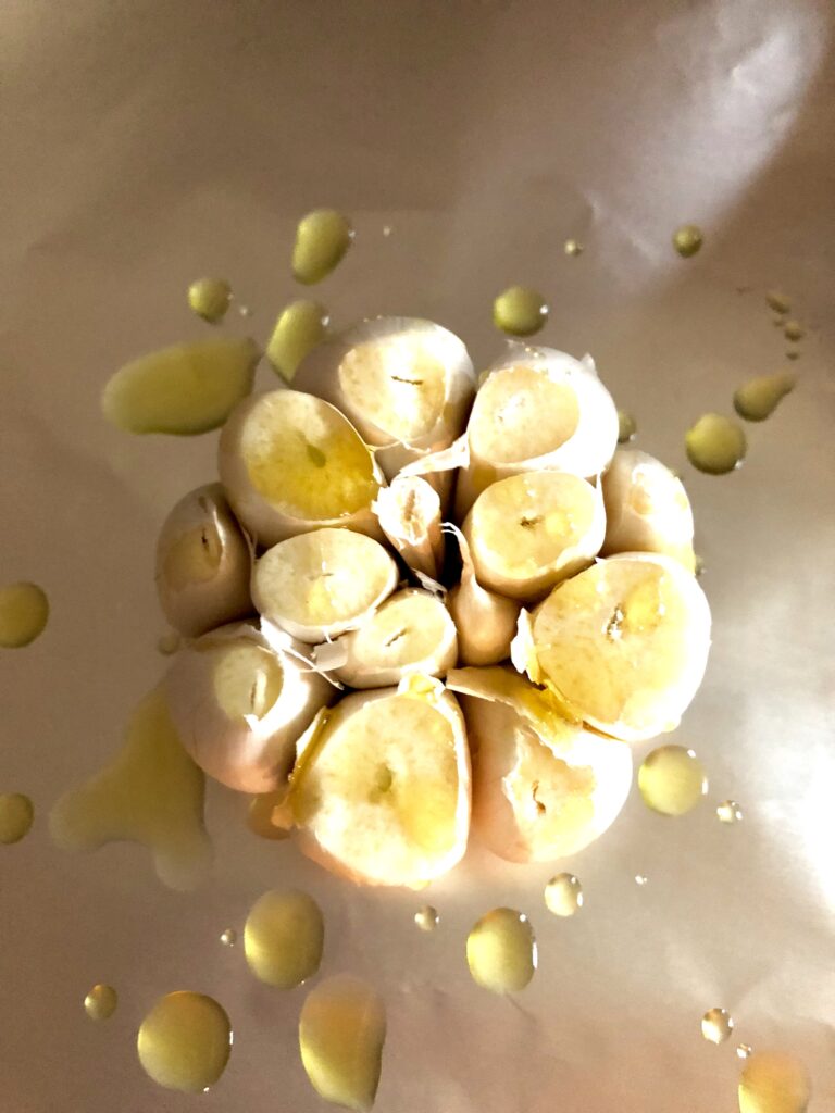 head of garlic with olive oil drizzled on top