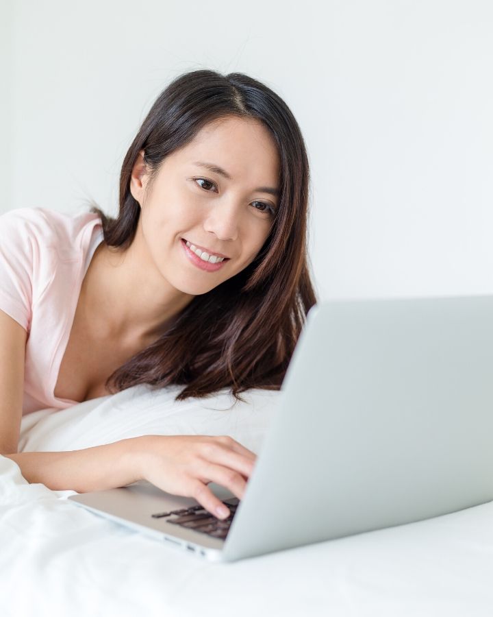 woman on laptop in bed