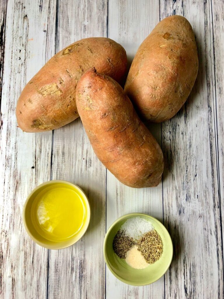 3 sweet potatoes, a small dish of olive oil and a small dish of spices