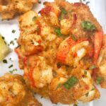 golden brown lobster cake garnished with lemon and parsley
