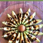 Avocado slices arranged around the pit to resemble a flower and drizzled with balsamic glaze
