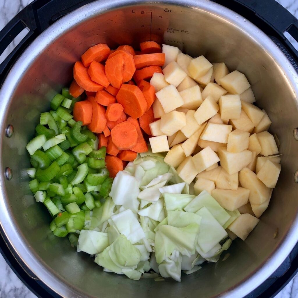Instant Pot with raw cabbage, turnip, carrots and celery inside
