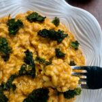Pumpkin risotto with a fork, small pumpkin in background