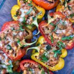 red, yellow, and orange stuffed peppers garnished with fresh basil