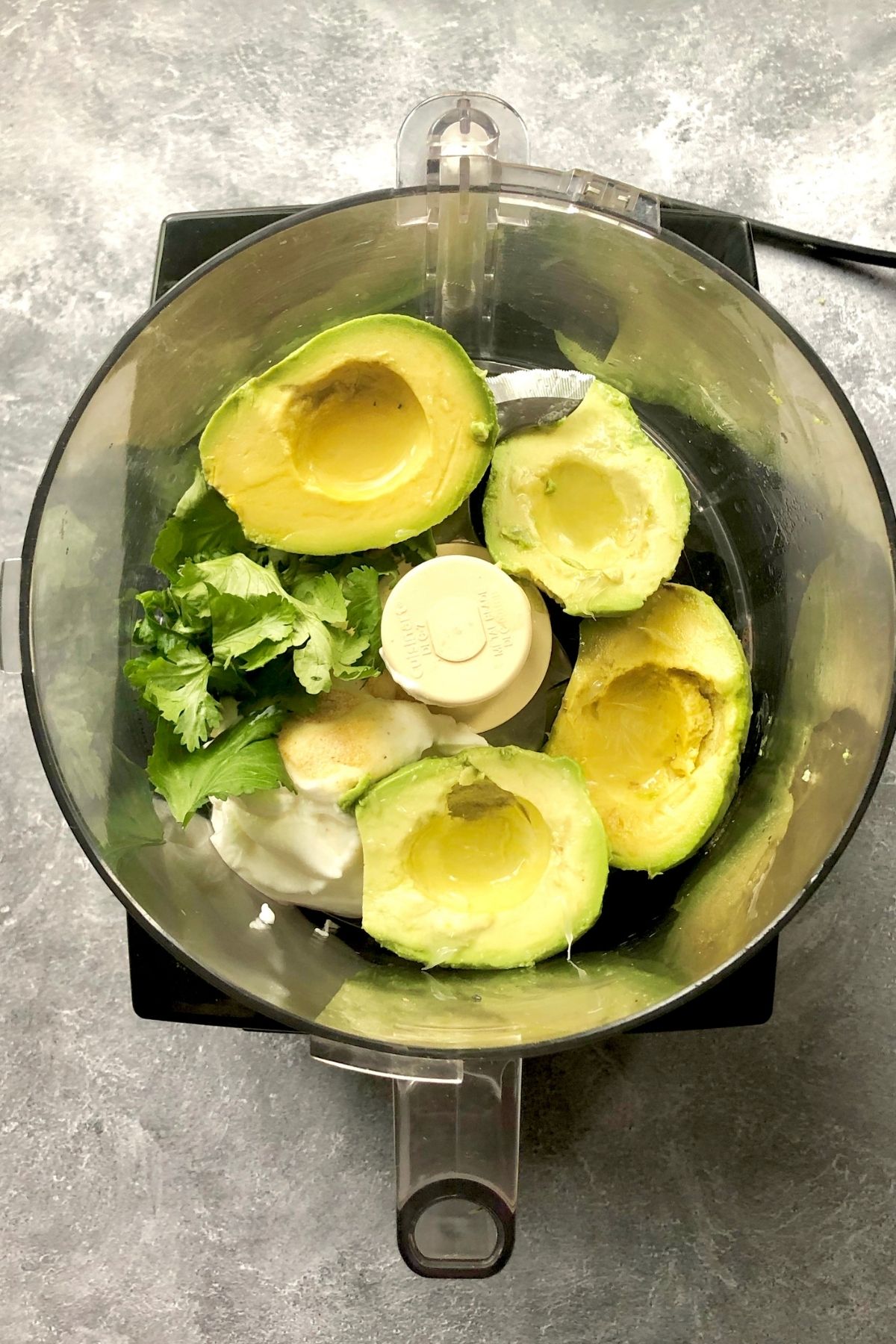 halved avocados, roughly chopped fresh cilantro, sour cream, lime juice, and garlic powder in the food processor