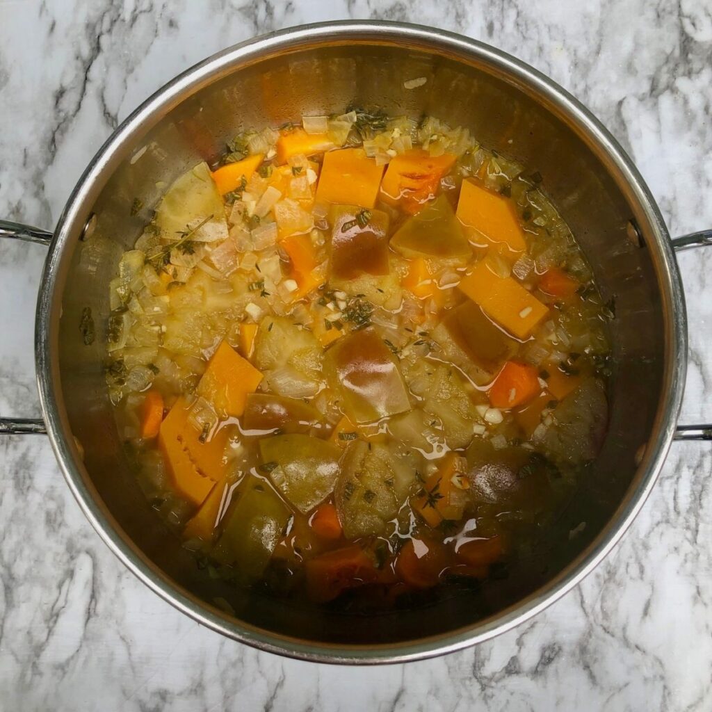 Cooked squash, apples, and other ingredients in a large pot