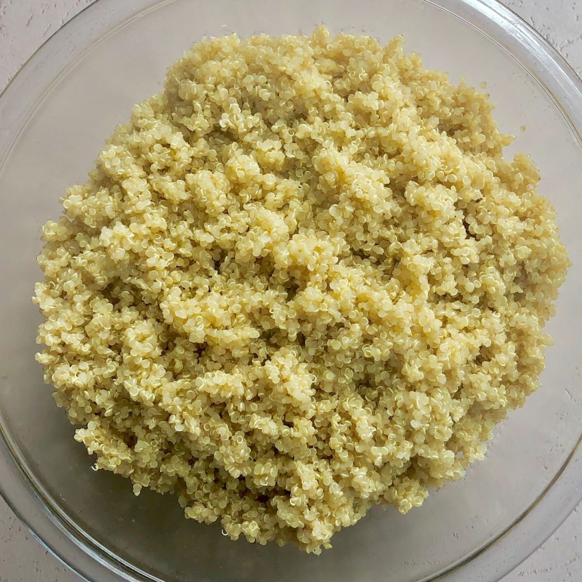 a glass bowl of cooked white quinoa