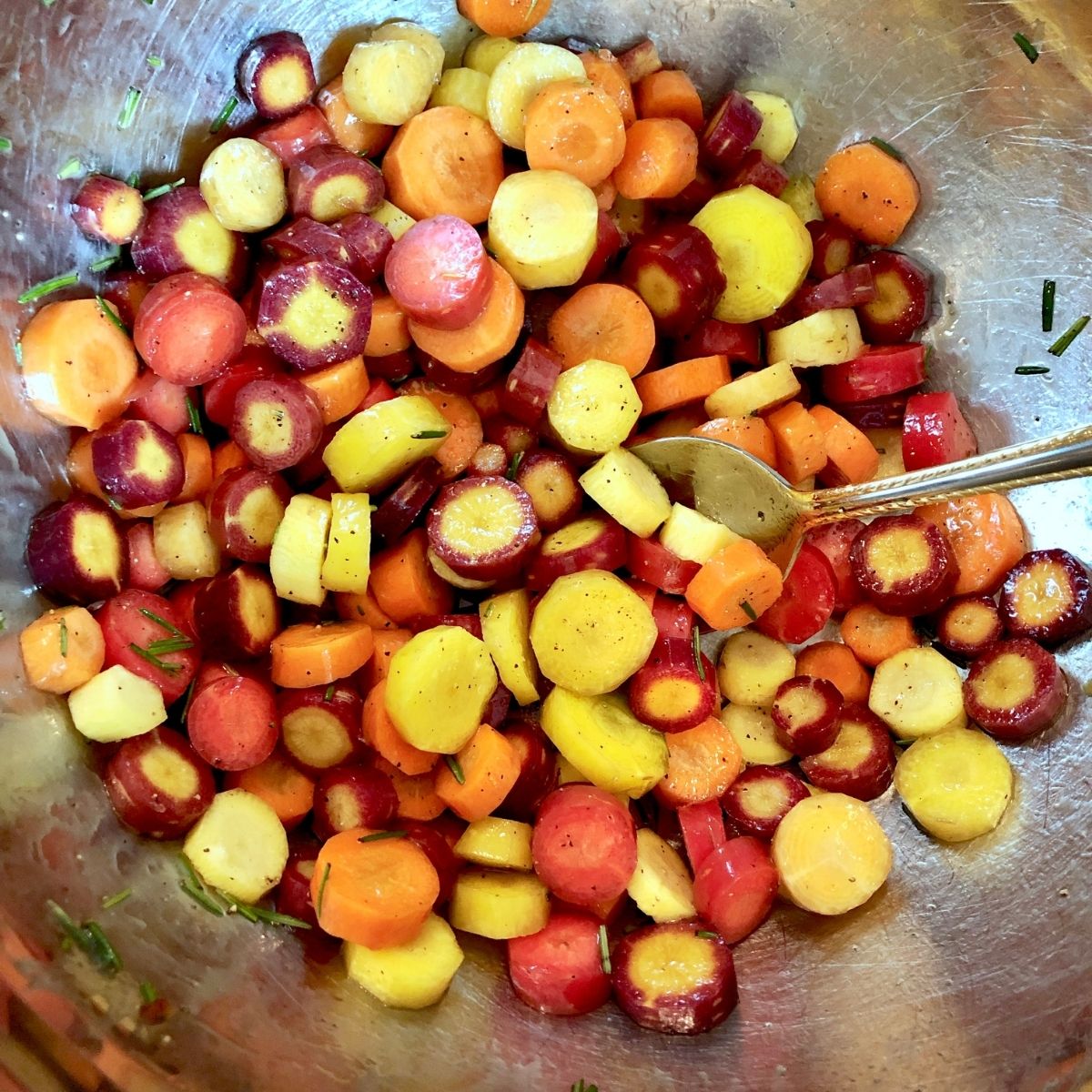 a mixing bowl full of sliced rainbow carrots