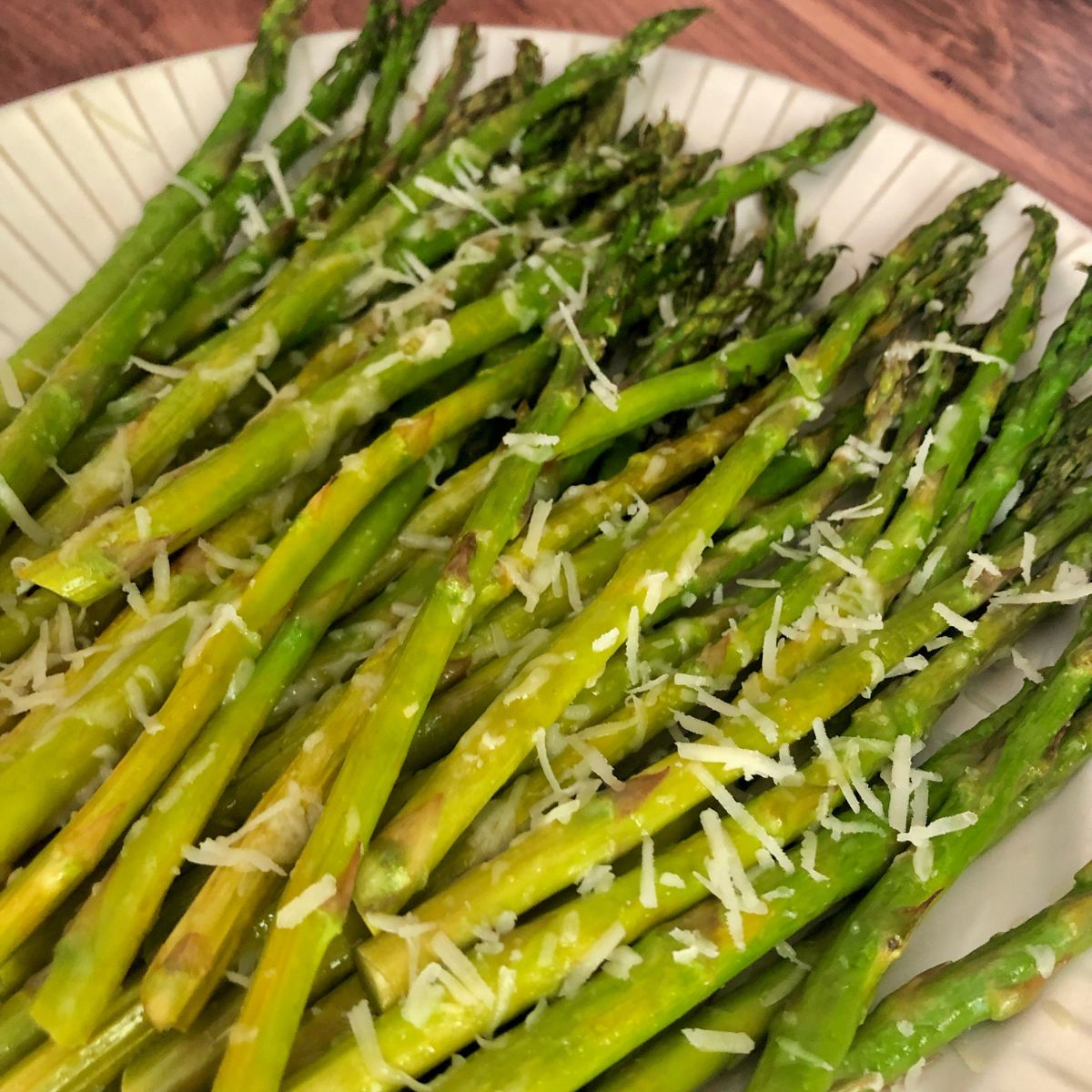 cooked asparagus spears garnished with grated parmesan