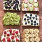 six slices of toast topped with spreads, fruits, veggies & seeds.