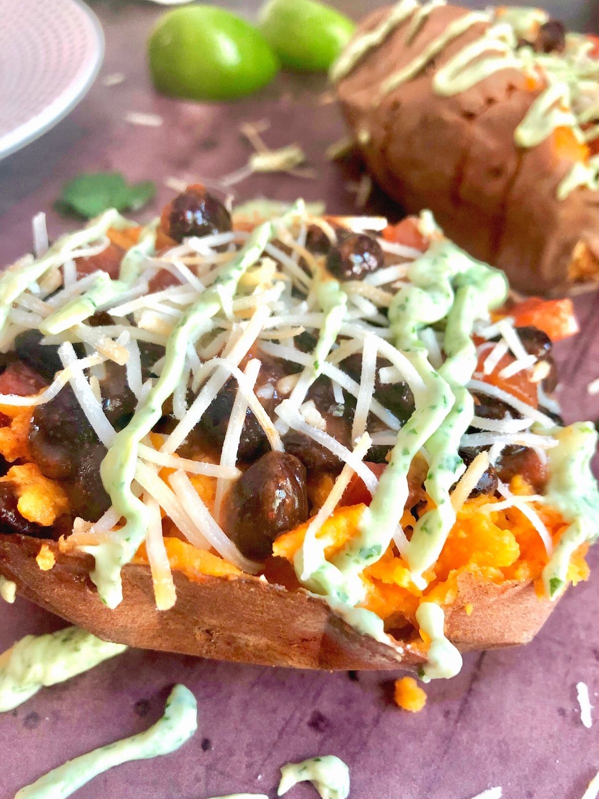 sweet potato stuffed with taco toppers: black beans and salsa, shredded cheese and drizzled avocado sauce.