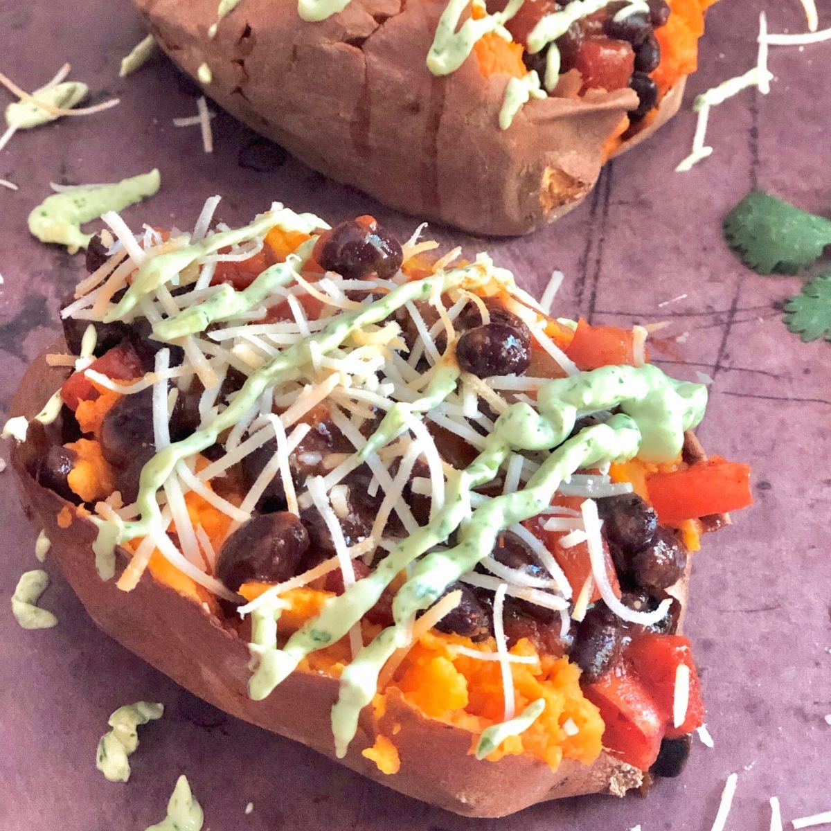 two sweet potatoes stuffed with black beans, salsa, cheese, and avocado sauce.