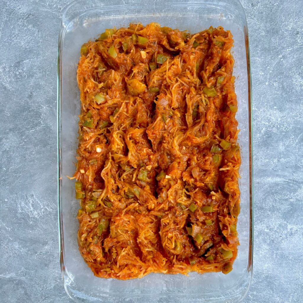 spaghetti squash and marinara sauce in a 9x13 baking dish.
