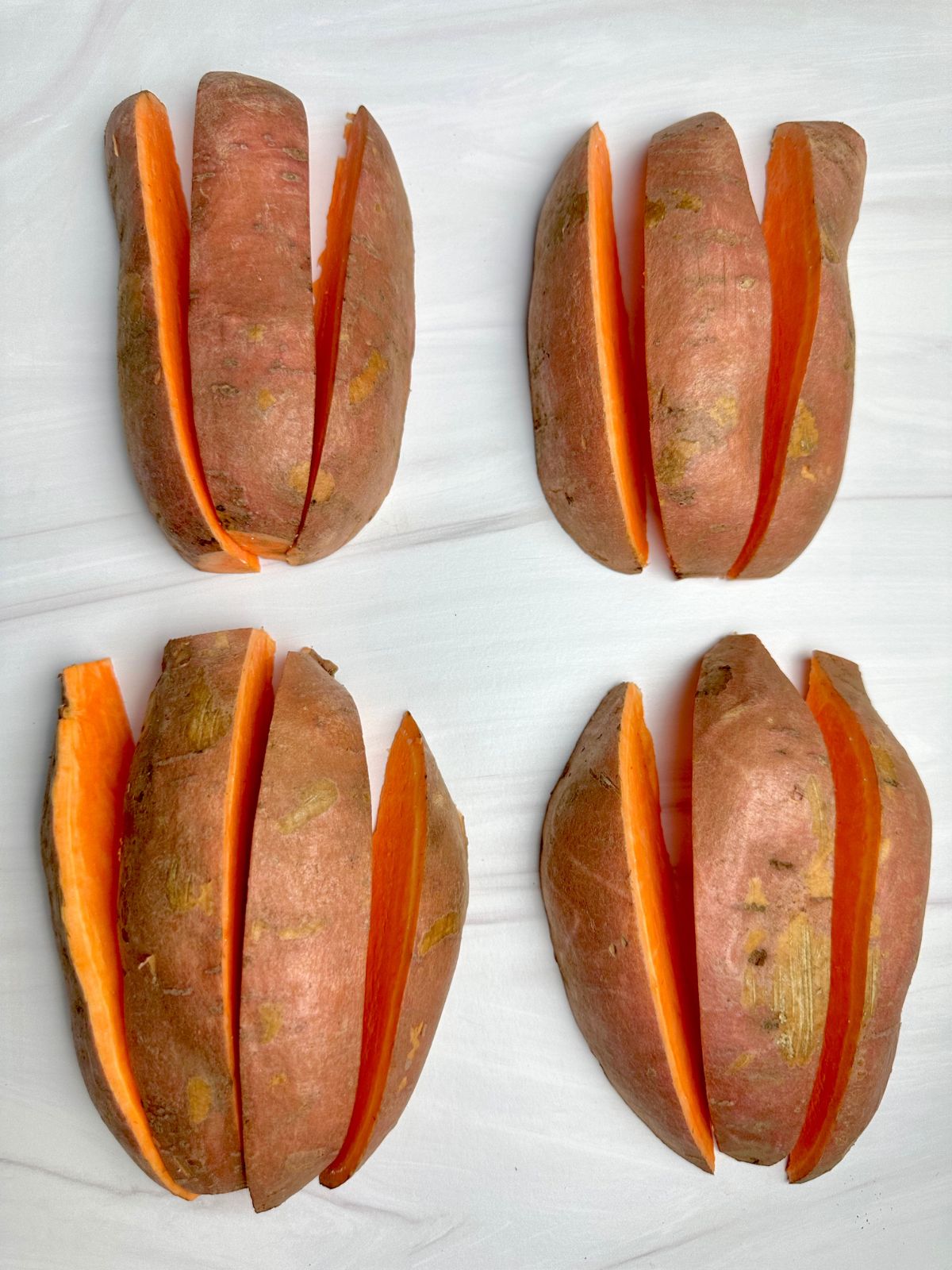 Four sweet potato wedges halves cut into wedges.