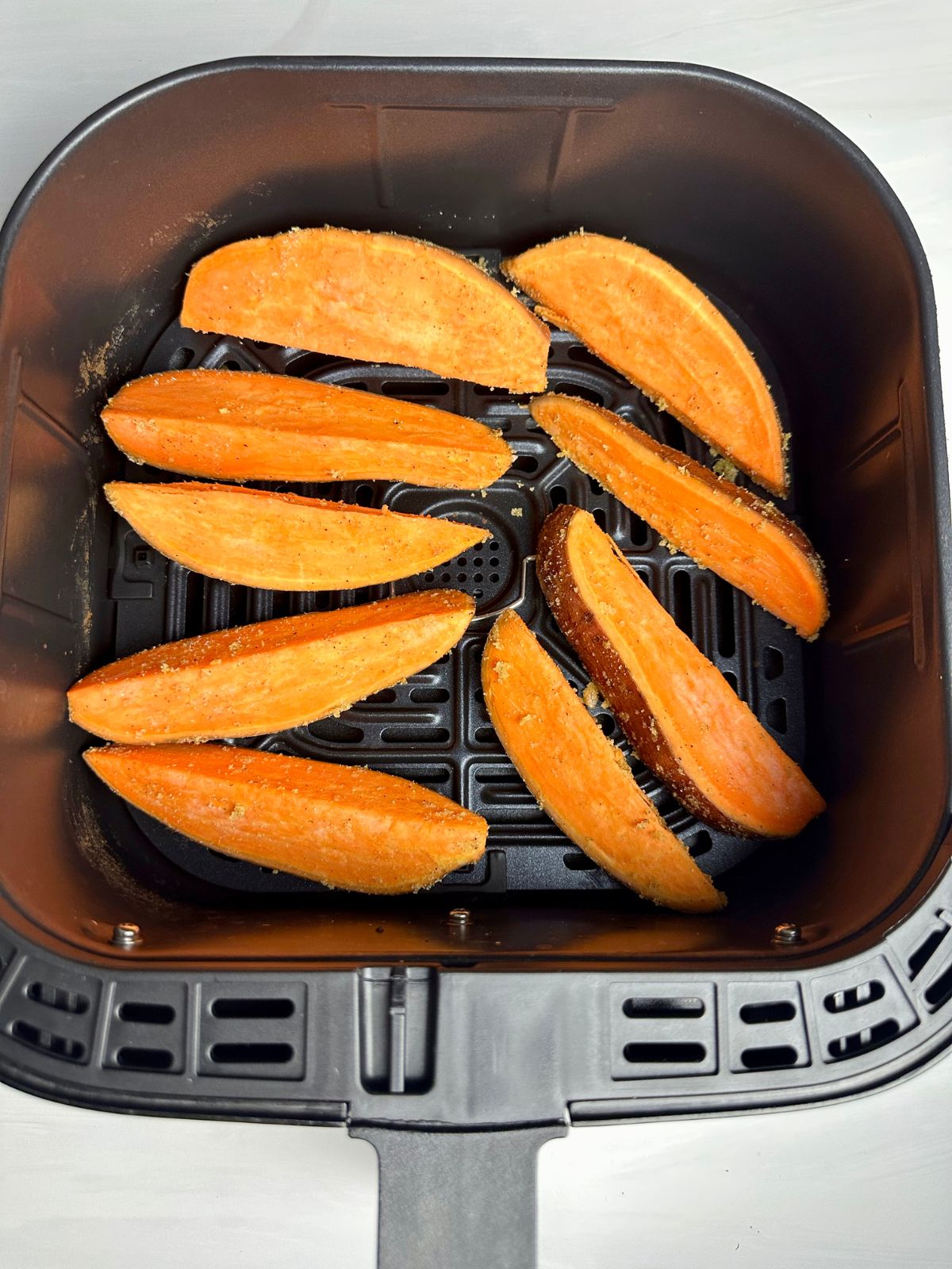 Sweet potato wedges in the air fryer basket.